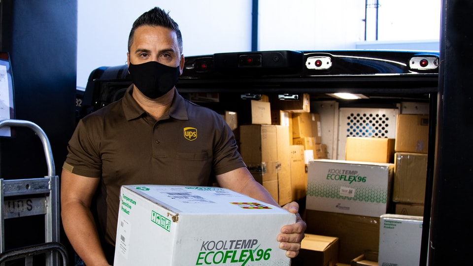 UPS driver delivering an early morning package of vaccines to a hospital